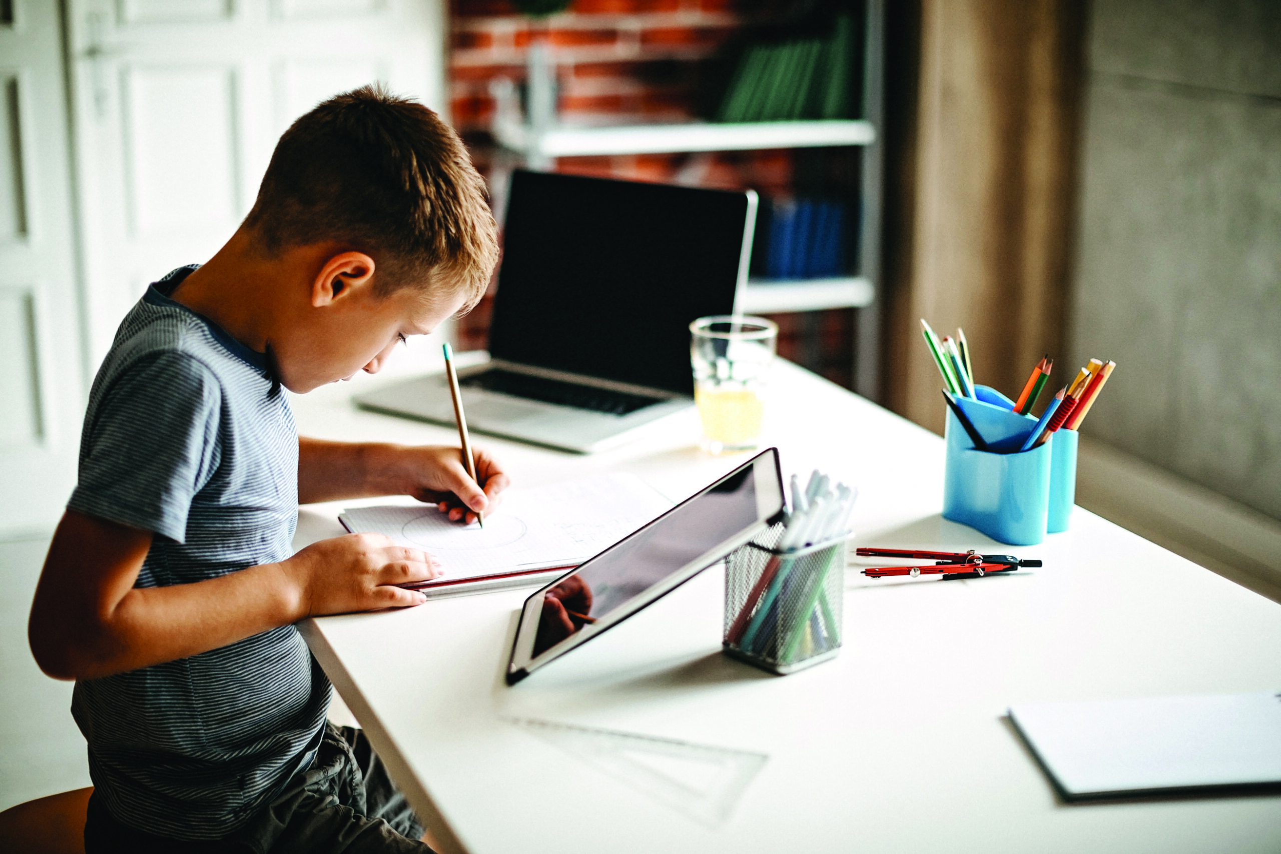 Kid learning for exam on digital tablet and laptop
