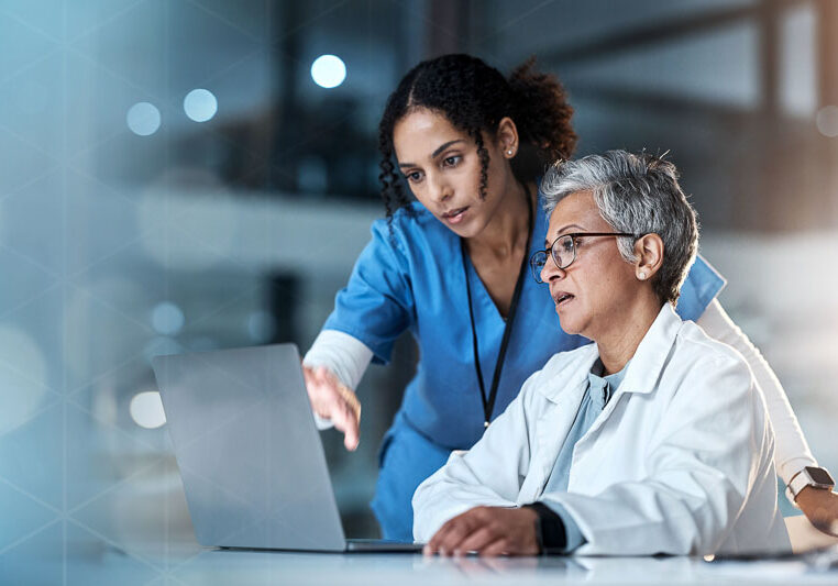 two female doctors looking at laptop screen together
