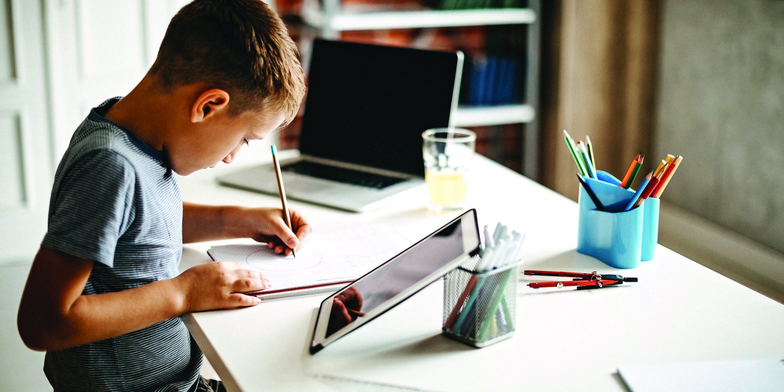 Kid learning for exam on digital tablet and laptop