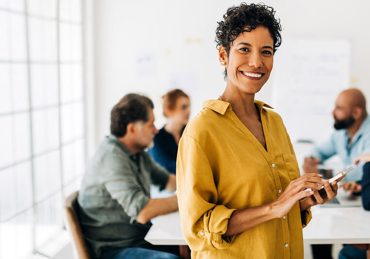 woman standing in front of work team at table