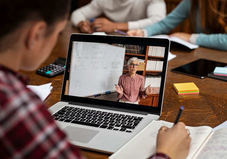 student engaged with online instructor on laptop
